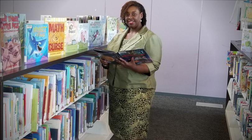 shaunte allen reading a book in the library